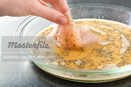 Dipping Chicken in Seasoned Egg; Step in Making Crunchy Baked Chicken