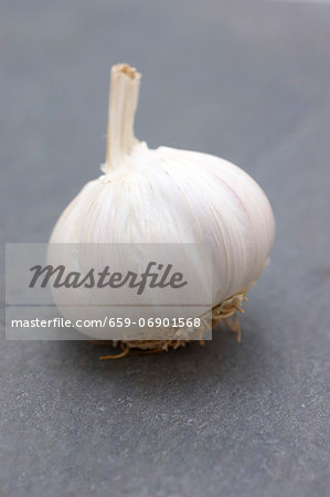 A garlic bulb on a slate surface