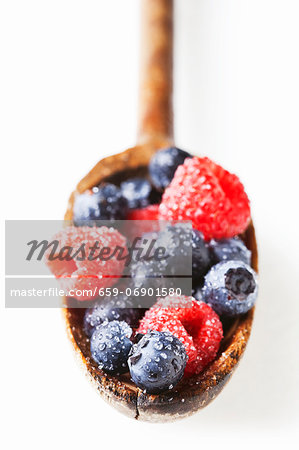 Washed Raspberries and Blueberries on a Wooden Spoon