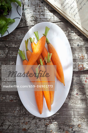 Peeled baby carrots on a plate (view from above)