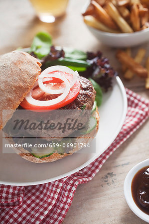 A home-made hamburger with cucumber, tomato and lettuce