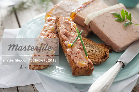 Toasted slices of bread spread with various types of pâté