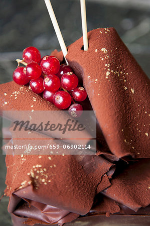 Chocolate cake topped with chocolate fans and redcurrants (close-up)