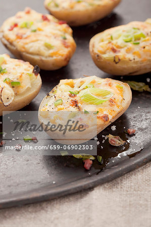 Stuffed baked potato halves with spring onions