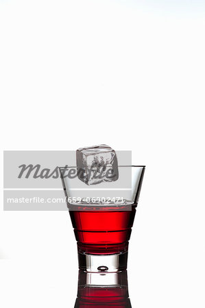 Ice cube falling into a glass of Campari Ice cube falling into a glass of Campari