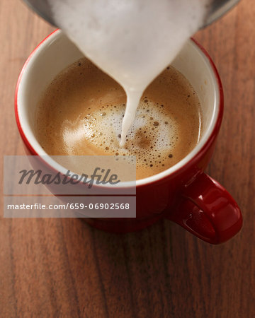 Milk foam being poured onto espresso Milk foam being poured onto espresso