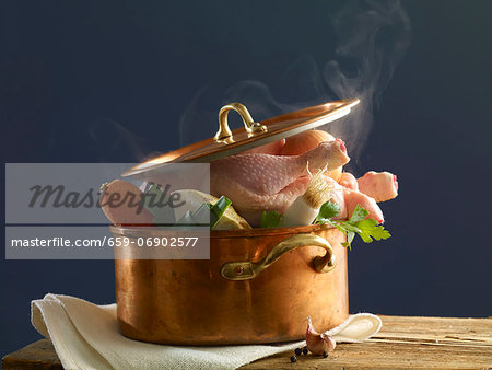 Stewing chicken with vegetables in a copper pot