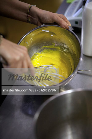 The egg yolk and sugar being whisked together