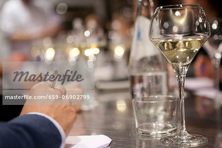 A glass of white wine on a reflective bar counter A glass of white wine on a reflective bar counter