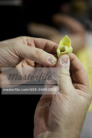 Two hands shaping a tortellino