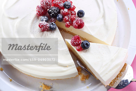 Cheesecake with berries, one slice cut (view from above) Cheesecake with berries, one slice cut (view from above)