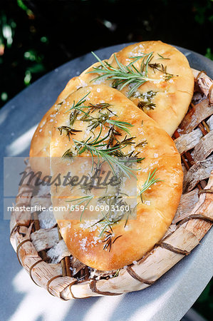 two Italian foccacia breads outside on a wooden tray
