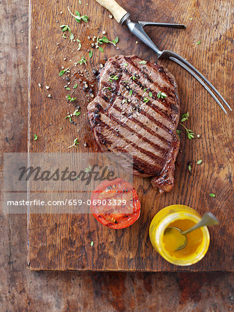 Grilled steak with grilled tomatoes and mustard