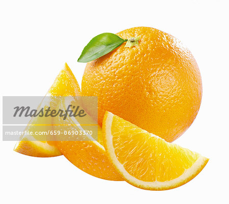 A whole orange with a leaf and orange wedges