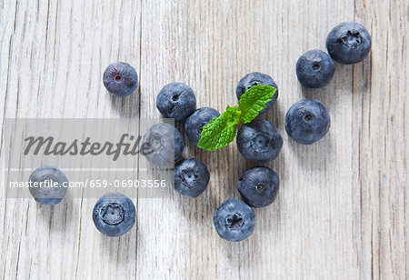 Blueberries and mint on a wooden slab, from above