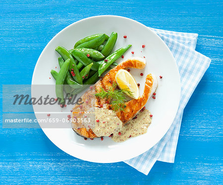 Fried salmon steak with sugar snap peas, honey and mustard sauce and red peppercorns Fried salmon steak with sugar snap peas, honey and mustard sauce and red peppercorns