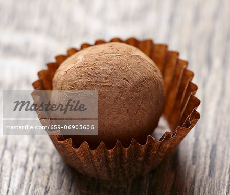 Close up of chocolate truffle on brown wooden table