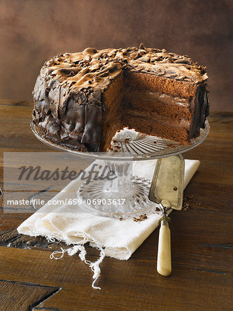 Removing Slice of Classic Chocolate Cake on Pedestal Dish