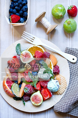A large fruit salad with mint ice cream A large fruit salad with mint ice cream