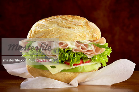 A roll filled with cheese, ham and salad