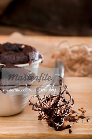 Chocolate melting middle puddings; an egg whisk with remnants of the raw mixture to one side