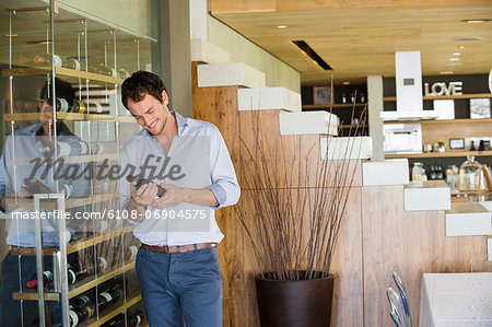 Smiling man looking at a wine bottle