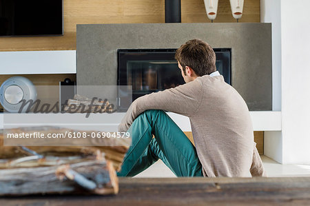 Man sitting in front of a fireplace at home