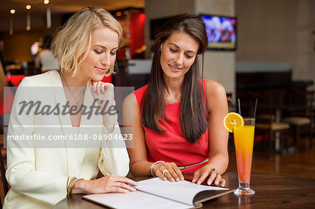 Two female friends looking at menu in a restaurant