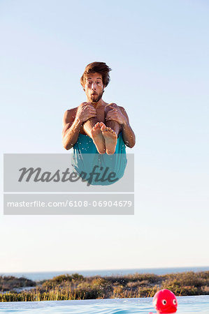 Man jumping into a swimming pool