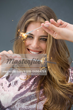 Woman celebrating with sparkler and smiling