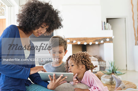 Woman showing a digital tablet to her children