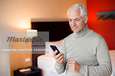 Man using a cell phone in a hotel room