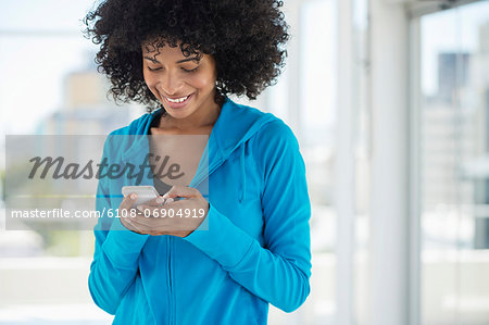 Smiling woman text messaging on a mobile phone