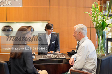 Business couple talking at a hotel reception counter