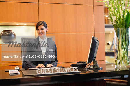 Portrait of a receptionist smiling at the hotel reception counter