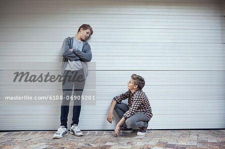 Two teenage boys looking at each other and discussing