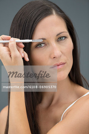 Portrait of a woman applying eyeliner