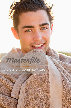Portrait of a smiling man wrapped in a towel