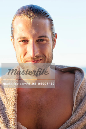 Portrait of a man wrapped in a towel and smiling