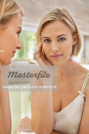 Woman checking her face in the mirror