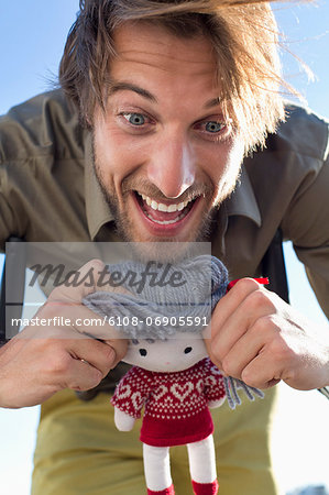 Man playing with a rag doll Man playing with a rag doll