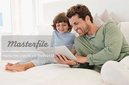 Man showing a digital tablet to his son