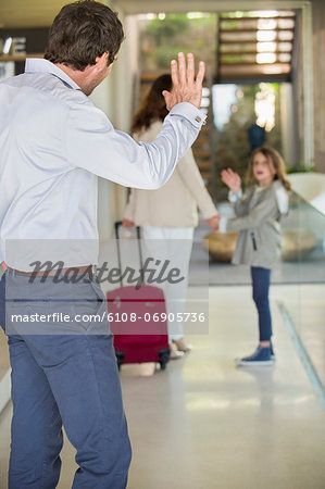 Man waving to his daughter leaving home