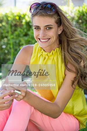 Portrait of a woman holding a mobile phone and smiling