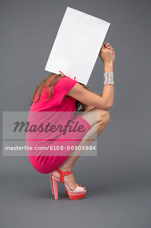 Woman holding a shopping bag over her face