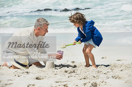 Boy playing with his grandfather on the beach