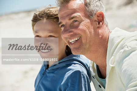 Man smiling with his grandson on the beach