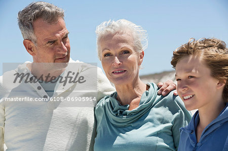Boy with his grandparents on the beach