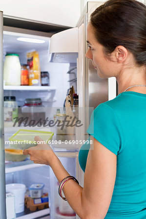 Woman putting food in a refrigerator