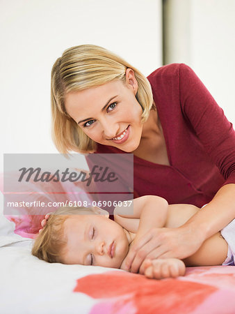 Woman near her baby sleeping on the bed